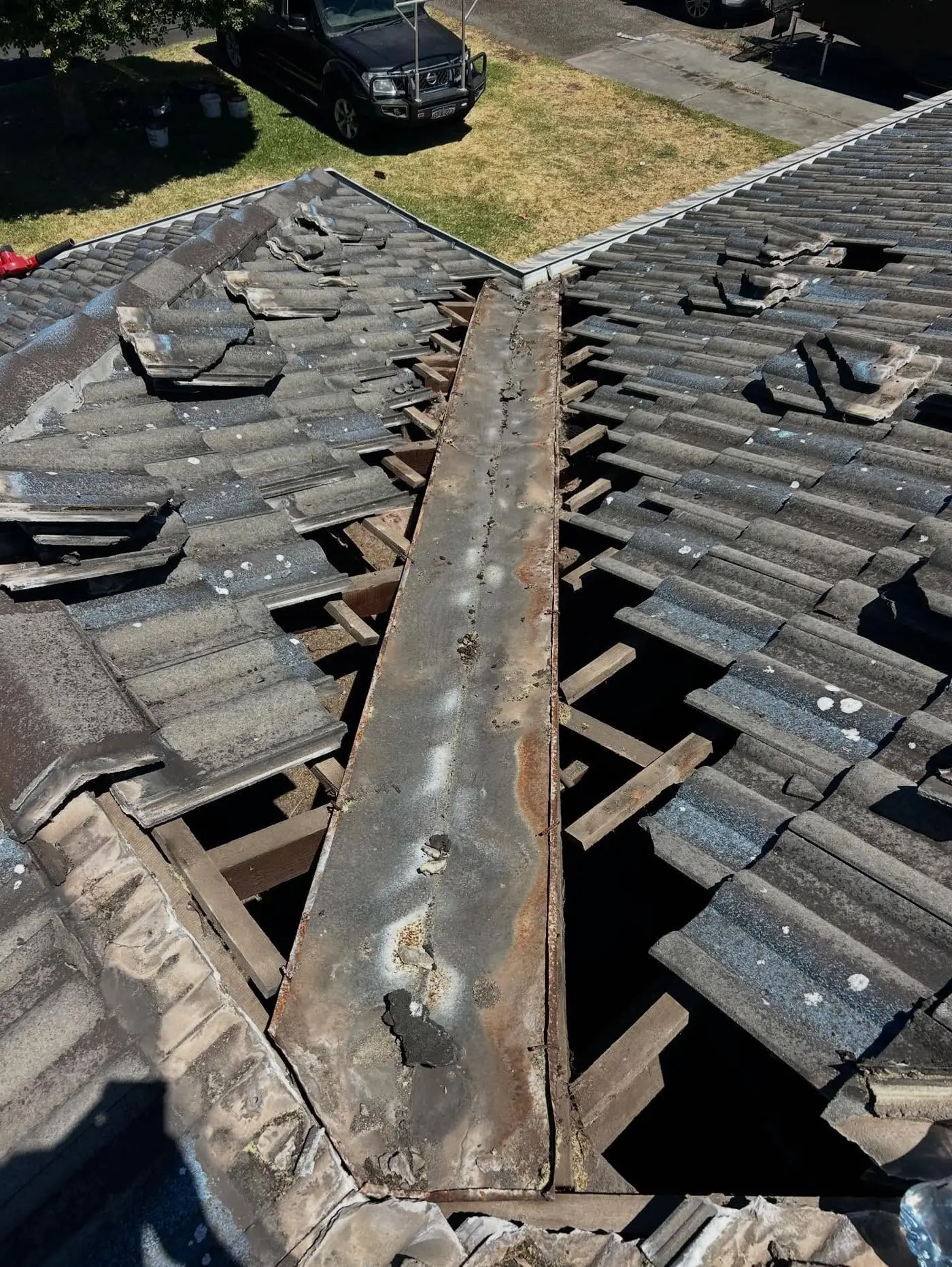 Valley tiles stripped back to the valley iron on a grey roof
