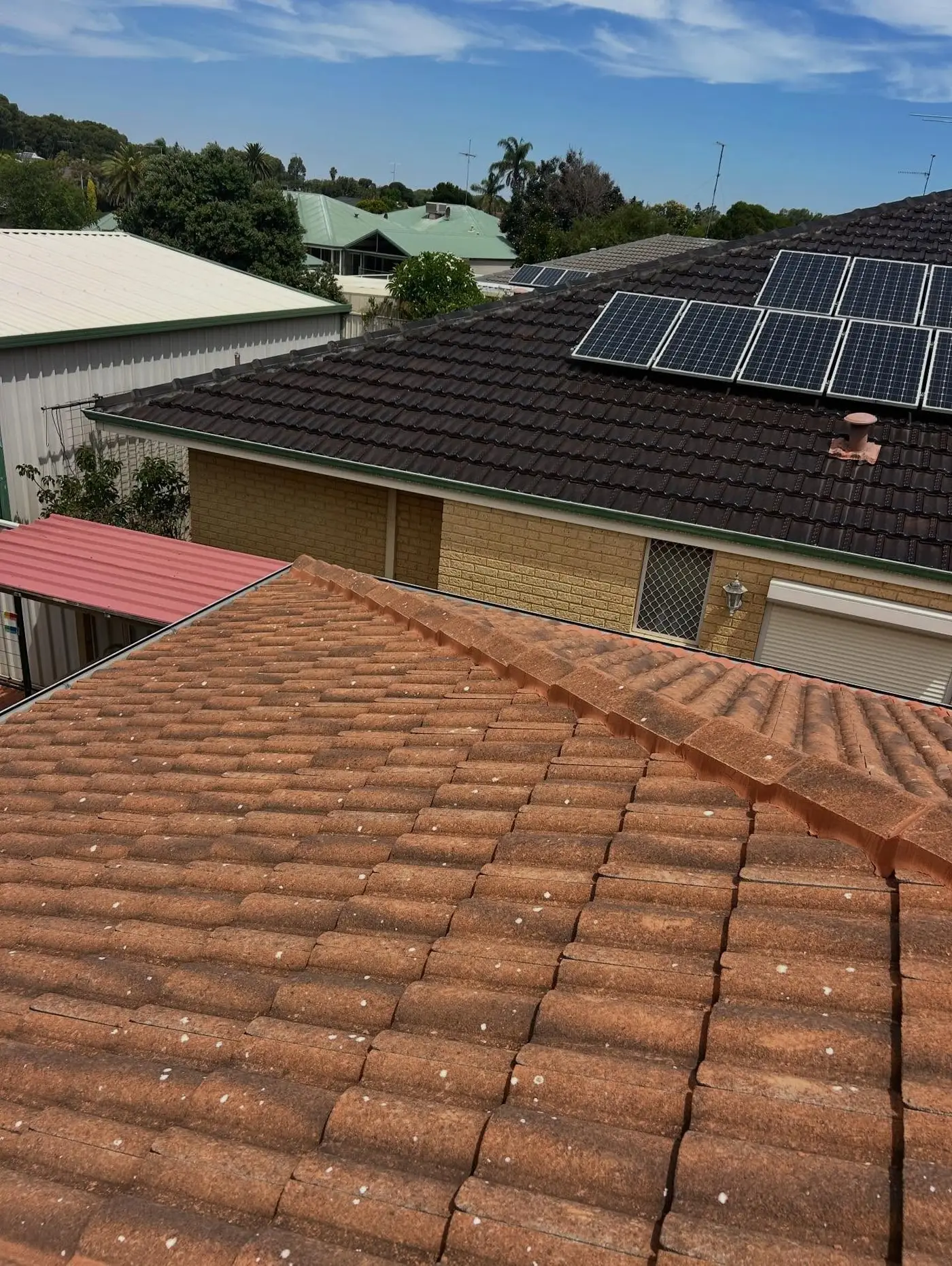 Terracotta tiled roof with neighbouring homes behind