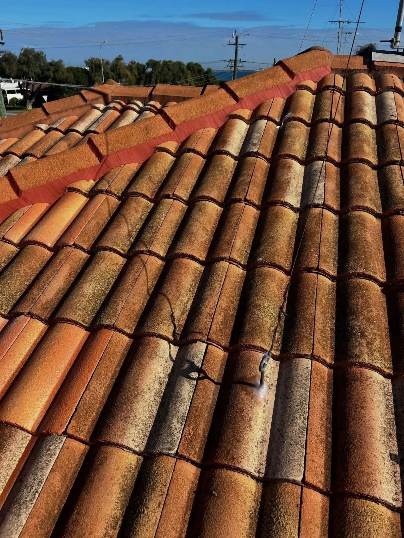 Terracotta tiled roof with a freshly pointed red ridge line