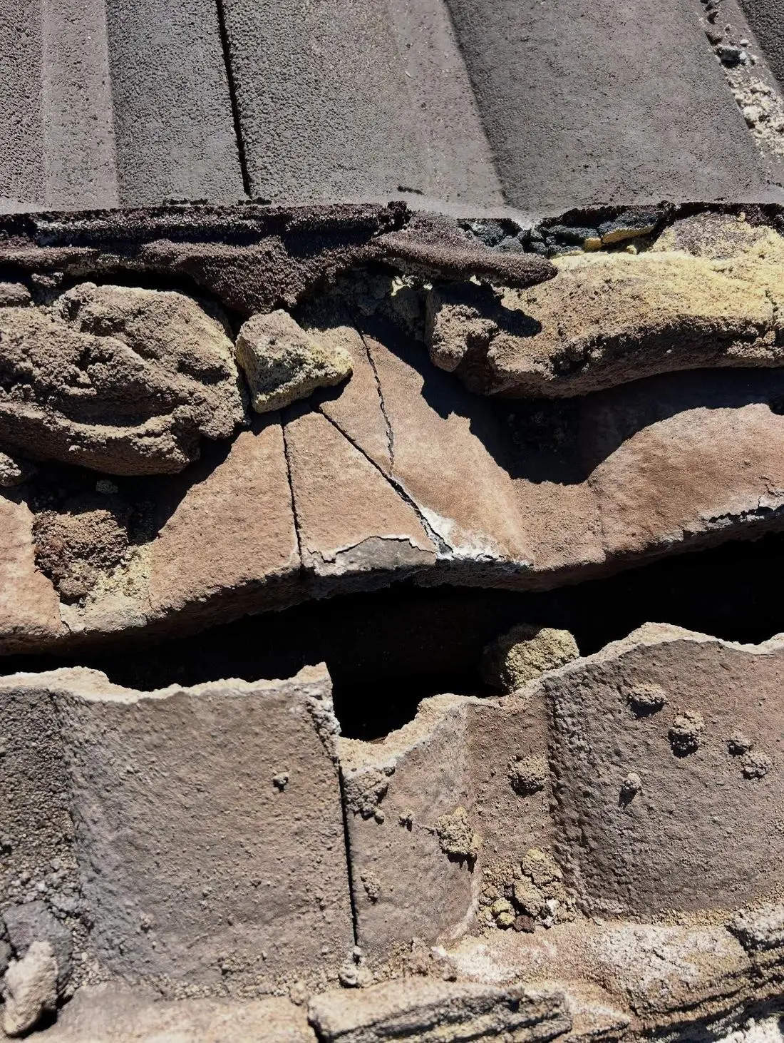 Cracked tile and crumbling mortar under the capping