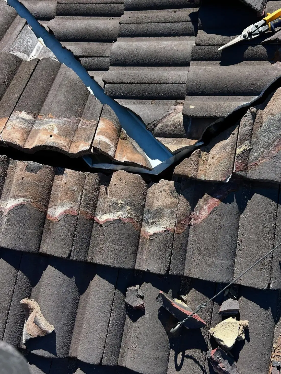 New valley iron being trimmed in beside charcoal roof tiles