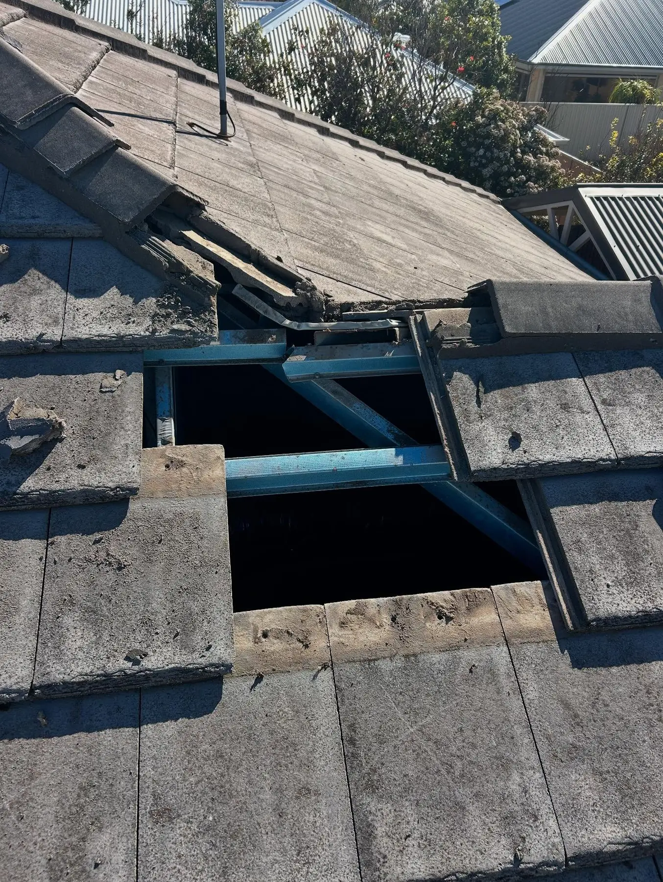 Grey roof tiles opened to access the structure below
